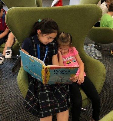 3rd grade buddies up for storytime in the NEW library