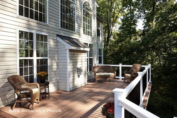 Vinyl deck using Wolf amberwood decking with rosewood border and Deckorators white PVC railing with black balusters.