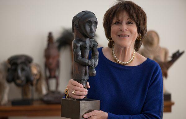 Maureen Zarember holding a rare Fang figure.