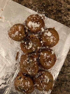 Deep fried Oreos sprinkled with powder sugar and drizzled with chocolate syrup