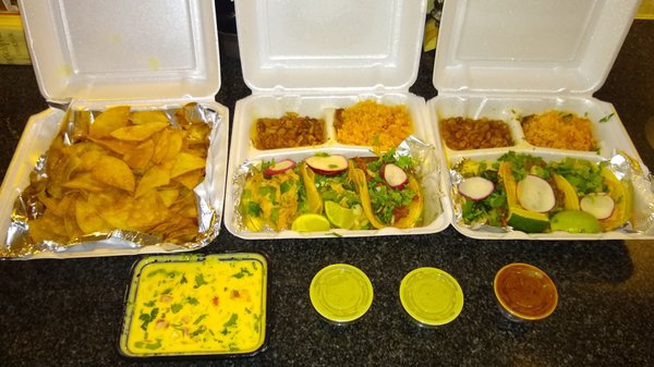 Real chips and queso with (2) 3 taco plates to go. The green sauce has a little kick, but the red - watch out...it's spicy!