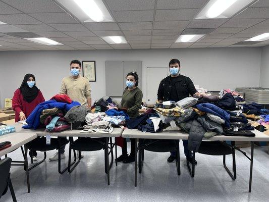 IILA refugee services staff help sort clothing donations for clients.