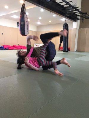 Coach Tyler teaching my daughter a classic sweep from Butterfly Guard.