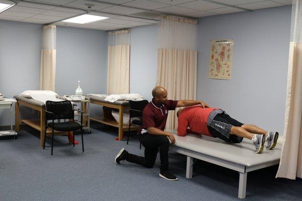 DPT doing plank with a patient in our treatment area