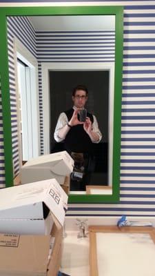 Hanging custom painted green mirror on stripe wall paper. Nathaniel Westcott pictured.