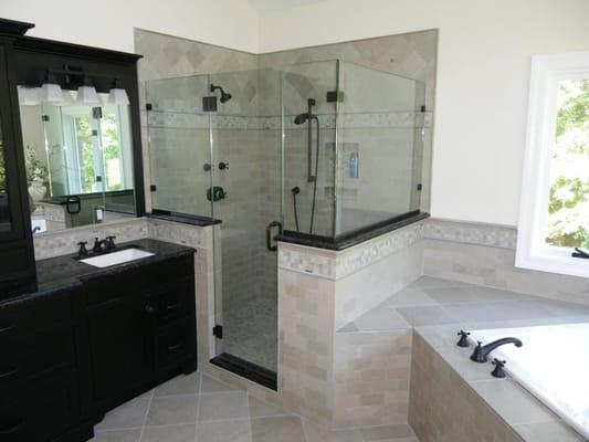 Glass and and marble shower with granite bench seat multiple Grohe shower heads.