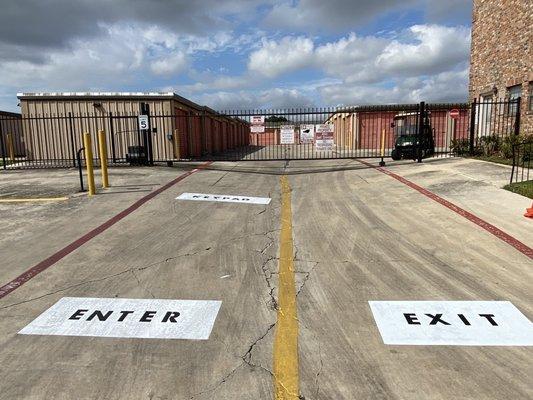 Gated entry to the storage units with newly painted signage for entry and exit