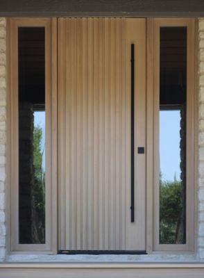 Custom rift sawn White Oak front entry door. This door utilizes a Fritsjurgens pivot hinge for dampening control.