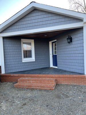 Removed a small 3 step entranceway and built out the porch, adding siding and recessed lighting in stained beadboard top.