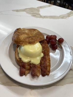 Flaky Buttery Croissant filled with crispy bacon, a perfectly poached egg, and topped with rich, creamy hollandaise sauce!