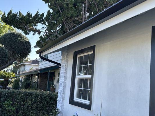 Front of house showing gutter up against fascia board. Downspout is hidden around the corner.