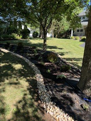 Garden Designed with 5 different types of plants, and irrigation system and a rock border.