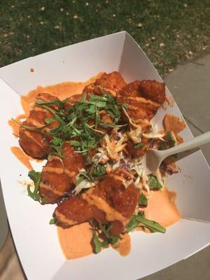 Garlic sriracha wings on a bed of arugula and shredded cabbage with sriracha mayo