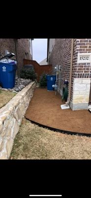 A crushed granite pathway for trash cans.