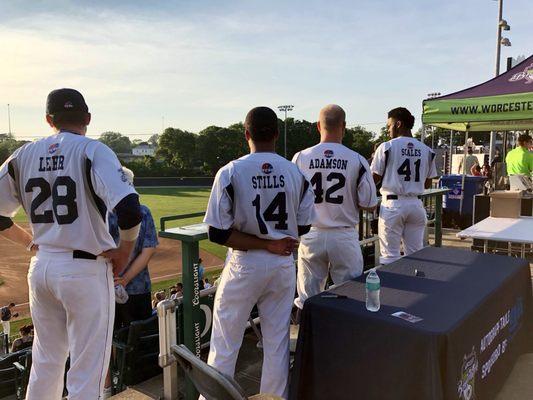 Players stand for the anthem at the pre-game autograph table