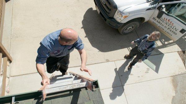 Our NFI-Certified installer climbs a ladder to the ground after performing work on a chimney.