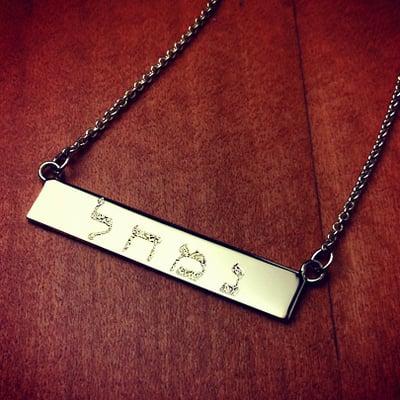 Custom engraved 14k yellow gold name bar necklace in Hebrew with etch fill engraving.