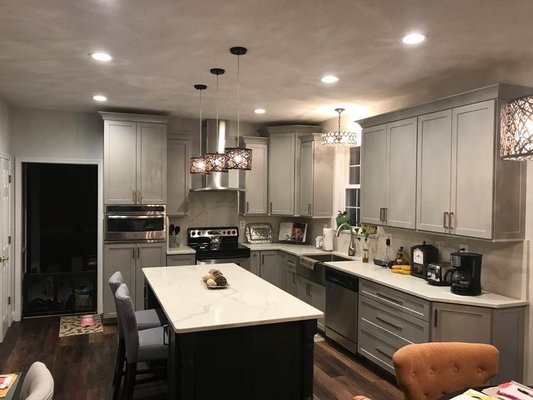 Renovated and removed peninsula. Added island. New grey cabinets with black island and quartz topcoat.