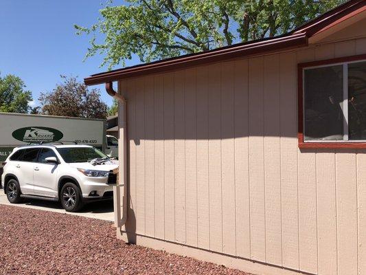 Gutter on the side of a garage with foldable downspout