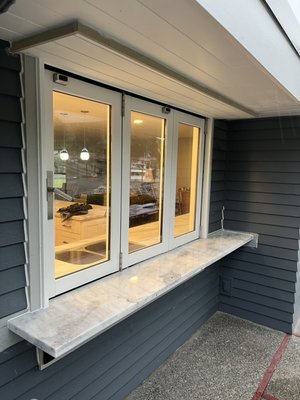 Custom pass through kitchen/bar window. Blending the inside and outside of a waterfront home.