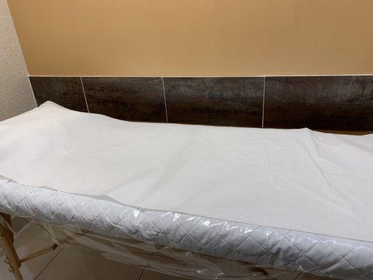 Service bed covered in plastic and the paper used in doctor's offices.