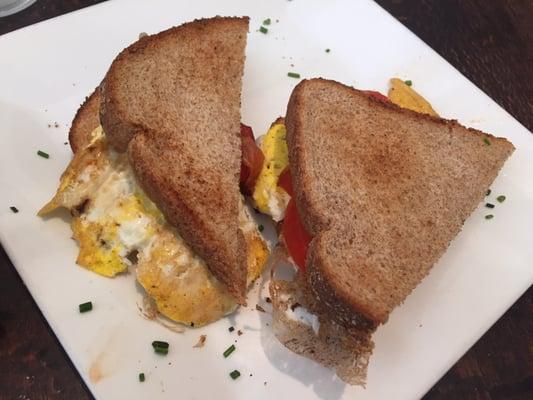 Egg sandwich with cheese and tomato.