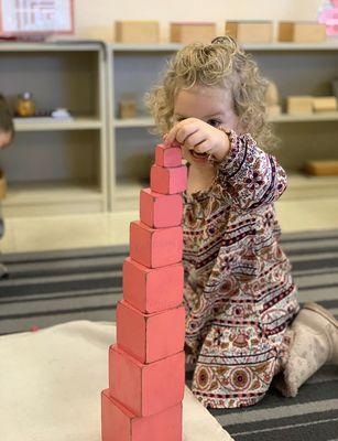 A student engaging with the Pink Tower!