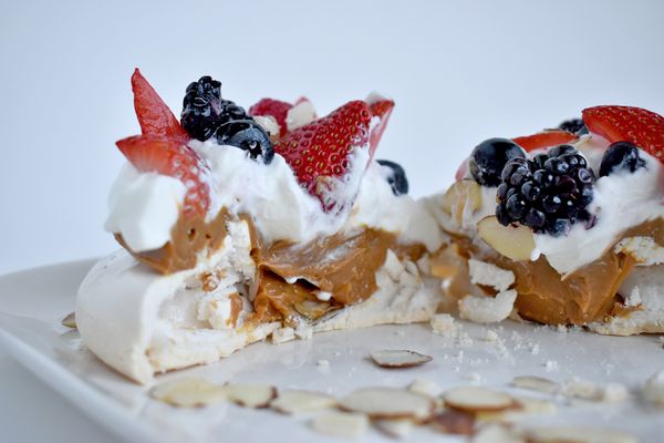 Bel's Pavlova: It's a meringue cake with a crisp exterior and marshmallow center. Filled with Dulce de leche and topped with fresh berries