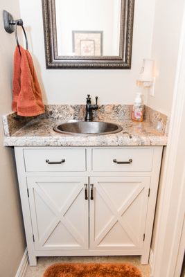 Updated half-bath. New cabinets, counter tops, sink, hardware, paint,  and flooring.