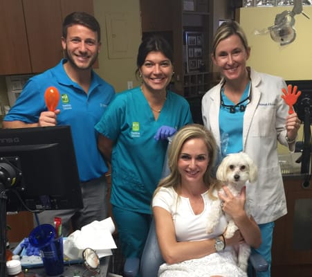 Dr Ferrer and Dr Herrero celebrating with a patient getting her braces