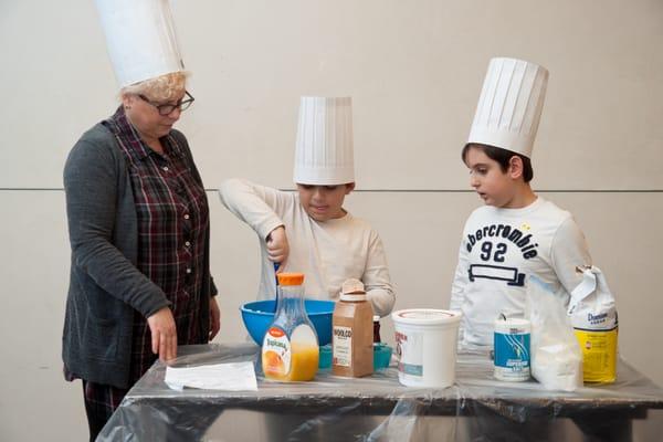 Children learn how to make sufganiyot (doughnuts) for the Chanukah holiday in Hebrew.