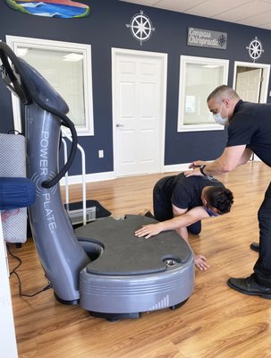 Dr. Brian guiding a patient through a few stretching exercises on the Power Plate in the Point Pleasant facility.