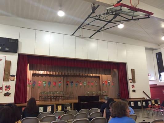 Gym stage set for graduation performances.