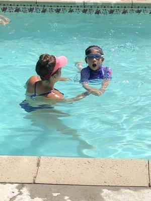 Samantha teaching Jade to take a deep breath before continuing on to swim across the pool.