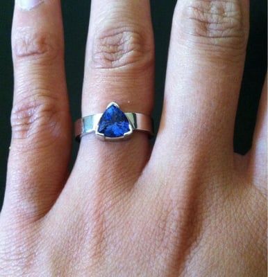 7mm trillion cut tanzanite in partial-bezel with flat 4mm white gold band