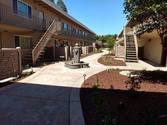 The newly re-landscaped interior courtyard features brand new patios for all ground-floor homes as well as a meandering path and fountain.