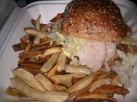 Turkey sandwich on ciabatta with apricot chutney with a side of fries.