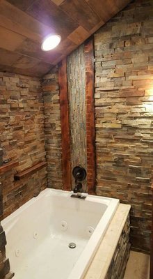 Whirlpool tub, with stacked stone and reclaimed wood.