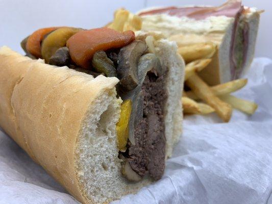 Fresh cut fries between halves of a knuckle sandwich and Italian sub.