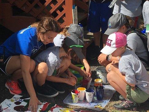 Volunteer works with campers on an art project at Camp Angel, a three-day experience for kids/teens whose parent/caregiver has or had cancer