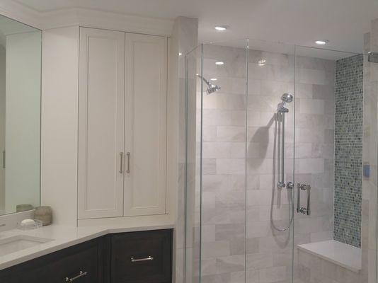 Removing an unwanted soaking tub opens up this primary bath for custom storage, a make-up vanity and spacious shower electronic controls.