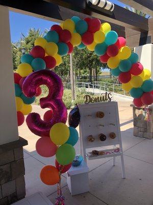 Balloon arch and number balloon with attached weights.