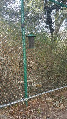 The feeder is secured to the fence with zip ties. The birds love it. I plan on buying another one for the hummingbirds next time.