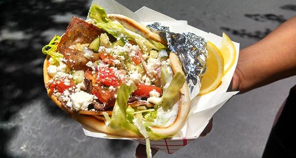 Grilldabeast Gyro- seasoned, grilled lamb gyro meat, lettuce, feta, tzatziki, and Mediterranean salsa, on warm pita