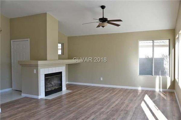 Living room - new interior wall paint, new ceiling paint, fixed ceiling fan and fireplace, new laminate floor.