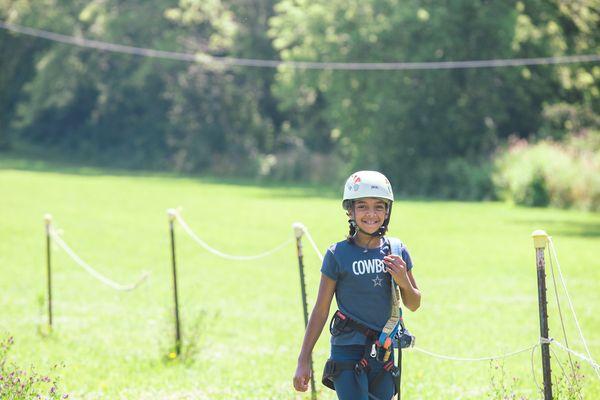 A camper walks back after completing a ride down the zipline