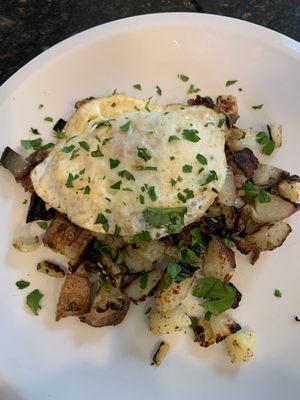 Over-easy egg atop Lambert's sautéed onion,potato and snipped parsley