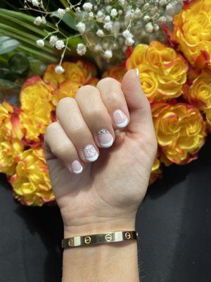 Chloe's nails, french tip slender almond shape with a crown chandelier design and crystals