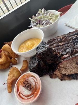 One meat plate with brisket, bbq sauce, sidewinder fries, liquid gold, and coleslaw.