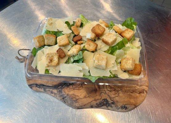 Classic Caesar: Romaine lettuce, Shaved and grated parmesan, croutons; served with our Caesar dressing on the side.